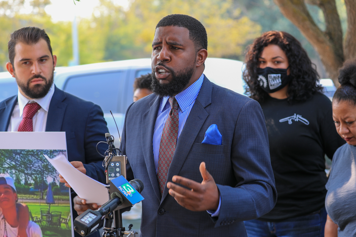 image of man in blue suit talking to news crew