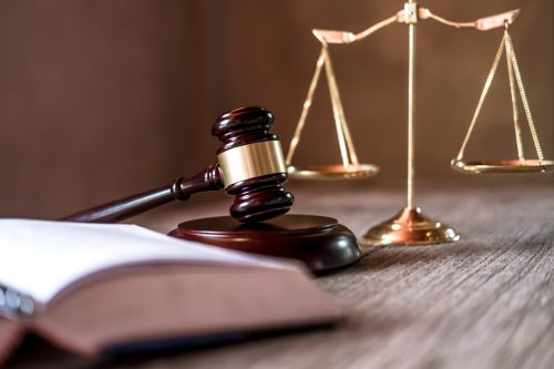 Gavel with open book and scales on table